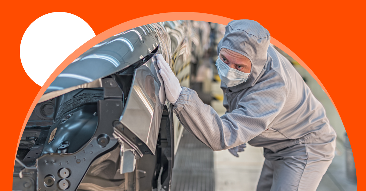 Factory worker in protective clothing and a mask inspects the exterior of a car on an assembly line, with a bright orange graphic background.