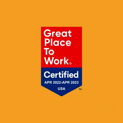 A badge displaying "Great Place to Work Certified" for USA from April 2022 to April 2023 on an orange background.